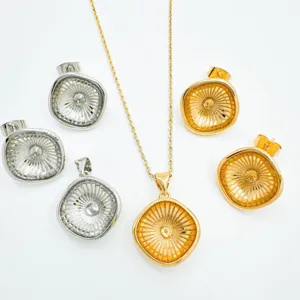 Detailansicht von kupfervergoldeten und silbernen Schmuck Anhänger und Ohrring Set.