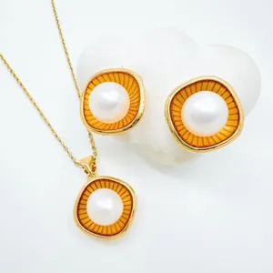 Elegantes Perlenschmuck Set mit Halskette und vergoldeten Ohrringen im Sonnenstrahlen-Design.