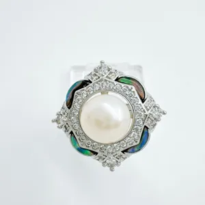 Close-up detail of a delicate DIY pearl ring with a central pearl and shiny crystals.