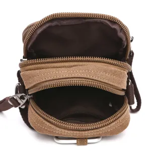Canvas crossbody bag interior detail showing multiple zippered compartments and brown lining.