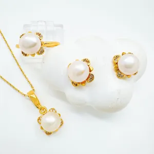 Vista detallada del conjunto de joyas con perlas y flores chapadas en oro y collares.