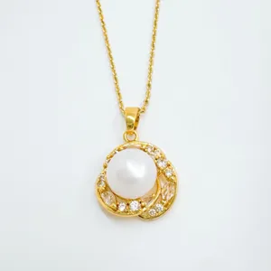 Detailed view of gold-plated pearl pendant necklace with shining cubic zirconia details.