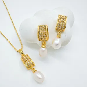 Detailed close-up of gold plated pearl necklace and earrings set with sparkling cubic zirconia.