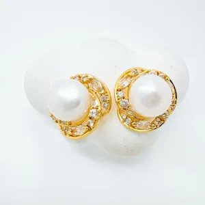 Pearl stud earrings detail shot, 18k gold plated copper with shining cubic zirconia stones.