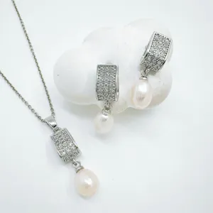Exquisite pearl jewelry set detail showing pendant necklace and matching earrings with sparkling zircon.
