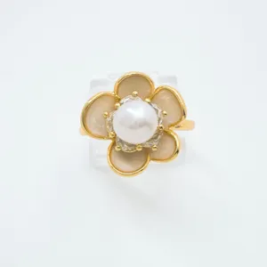 Close-up of a delicate gold plated camellia flower pearl ring showcasing intricate details.