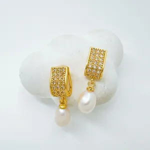 Gold-plated cubic zirconia pearl drop earrings, elegant jewelry detail shot showing fine craftsmanship.