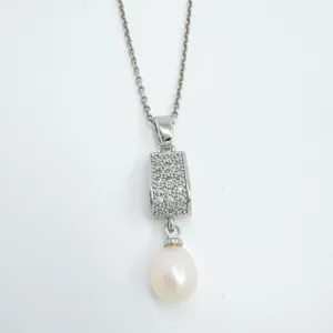 Detailed close-up view of silver-toned pendant necklace with sparkling zircon and dangling pearl.