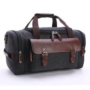 Vintage black canvas travel duffel bag with brown leather accents and shoulder strap.