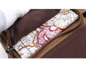 Canvas chest bag detail view showing durable brown fabric, smooth zipper, and vintage map lining.