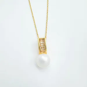 Elegante goldene Halskette mit funkelnden Baguette Steinen und feinem Perlen Anhänger.