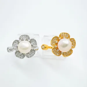 Detail shot of floral pearl cubic zirconia rings in silver and gold tone, elegant jewelry accessory.