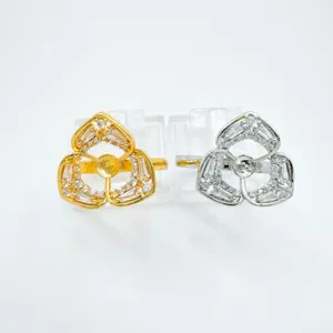 Detailed close-up view of fashionable floral clover ring settings, dual gold and silver colors.