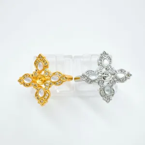 Detail shot of cross rings with white mother-of-pearl and cubic zirconia in gold and silver finish.
