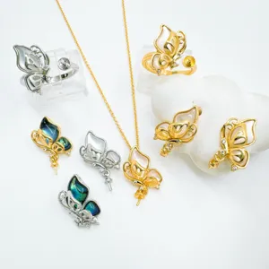 Close-up detail of butterfly pearl jewelry set components, including pendant and rings.