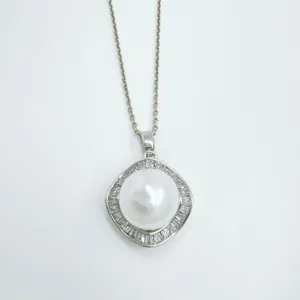 Pearl pendant detail shot, geometric silver-tone setting with sparkling pave cubic zirconia halo.