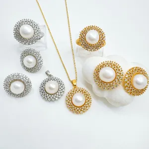 Pearl jewelry set featuring gold and silver sunburst rings, earrings, and pendant necklace.