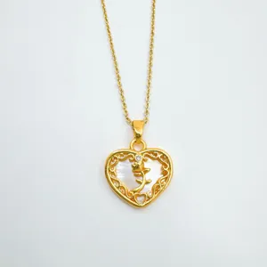 Détail de pendentif collier cœur doré avec nacre naturelle et délicat motif de rose florale.