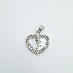 Détail pendentif cœur en nacre, accessoire bijoux en métal argenté avec arabesques.