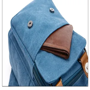 Blue canvas backpack stylish casual travel bag with brown pocket detail and metal snaps.