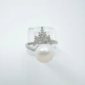 Primer plano detallado de anillo de perla y corona, diseño elegante con zirconias.