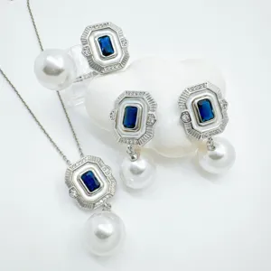 Vintage pearl jewelry detail showcasing rectangular blue stone pendant and elegant matching earrings.