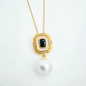 Vintage gold geometric pendant necklace with white enamel, blue center stone and pearl drop.