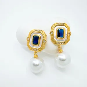 Detailed close-up view of vintage rectangular blue crystal earrings with hanging pearl charm.