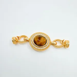 Détail de fermoir de bijoux en or, œil-de-tigre ovale avec de beaux zircons brillants.