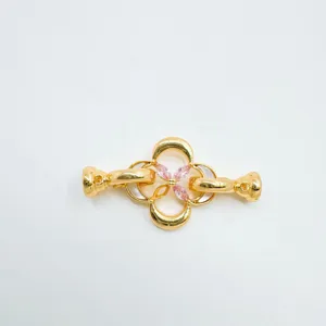 Gros plan sur le détail du fermoir trèfle de bijoux dorés avec zircone, belle pièce DIY.