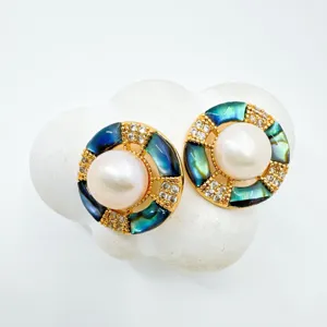 Close-up detail of pearl abalone shell geometric gold plated earrings with micro pave crystals.