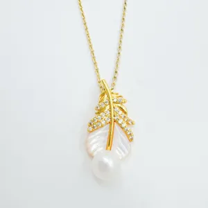 Exquisite gold plated feather pendant necklace featuring mother of pearl and hanging white pearl.