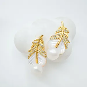 Close-up detail of elegant gold-plated feather pearl earrings with mother-of-pearl and zircon.