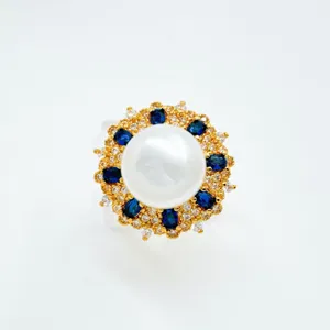 Detailaufnahme des Vintage Perlenrings im Sonnenblumen Design mit blauen Edelsteinen.