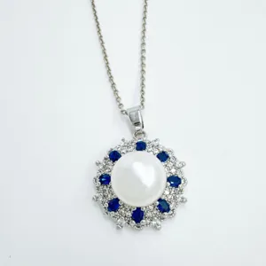 Nahaufnahme der Vintage-Perlenkette mit blauem Edelstein- und Strass-Sonnenblumen-Anhänger.