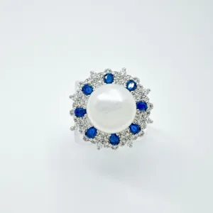 Nahaufnahme Detail des Vintage Perlenrings mit einer großen Perle umgeben von blauen Steinen.