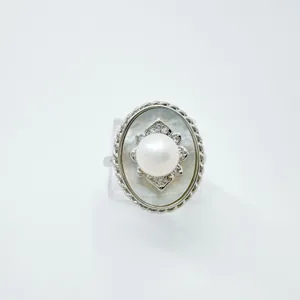 Anello ovale vintage con perla centrale, dettagli brillanti e raffinato bordo cordonato.