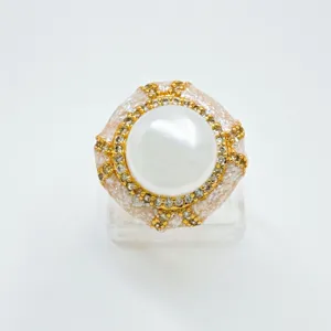 Exquisite pearl ring detail shot, featuring a large center pearl with gold rhinestone geometric mount.