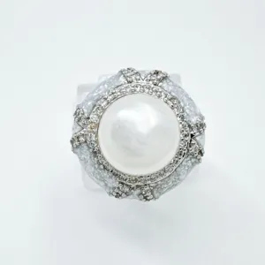 Detailed shot of DIY pearl ring blank with central pearl and rhinestone pave embellishment.