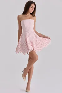 Close-up detail of the elegant pink strapless mini dress, featuring intricate hollow-out lace patterns.