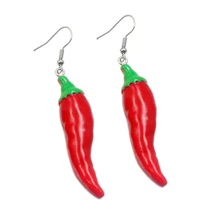 Detailed view of handmade resin chili pepper earrings, vibrant red and green food play charm.