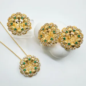Elegante set di gioielli floreali dorati con strass scintillanti e pietre preziose verdi.