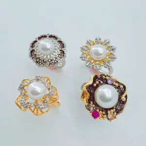 Close-up detail of exquisite freshwater pearl rings featuring intricate gold-plated zircon designs.