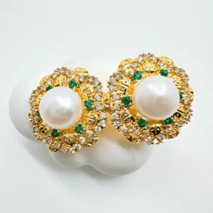 Elegante set di gioielli con ciondolo in perle e pietre preziose dal design floreale dorato e intricato.