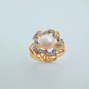 Close-up detail of the elegant floral ring featuring a central pearl and sparkling cubic zirconia.