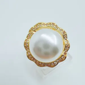 Edles Perlenanhänger Detail mit goldenem Spitzenrand und funkelnden Zirkoniasteinen im Fokus.