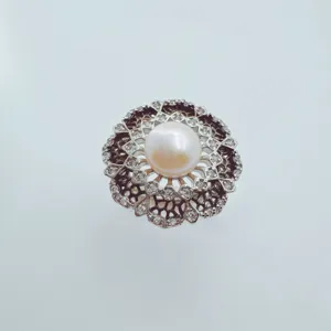 Detailed close-up of a vintage hollow pearl ring with sparkling zircon stones and shiny metal.