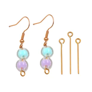 Gros plan de boucles d'oreilles de perles DIY et d'épingles dorées, perles bleues et violettes.
