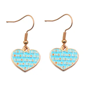 Vista dettagliata di orecchini a cuore smaltato azzurro con motivo love e gancio oro.