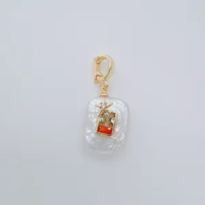 Detailed close-up of a baroque freshwater pearl pendant with gold-plated clasp and colorful stones.